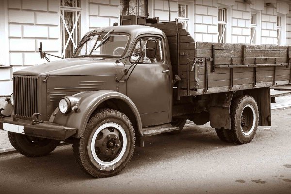 mehrere LKWs und große Container mit Sonnenaufgang im Hintergrund