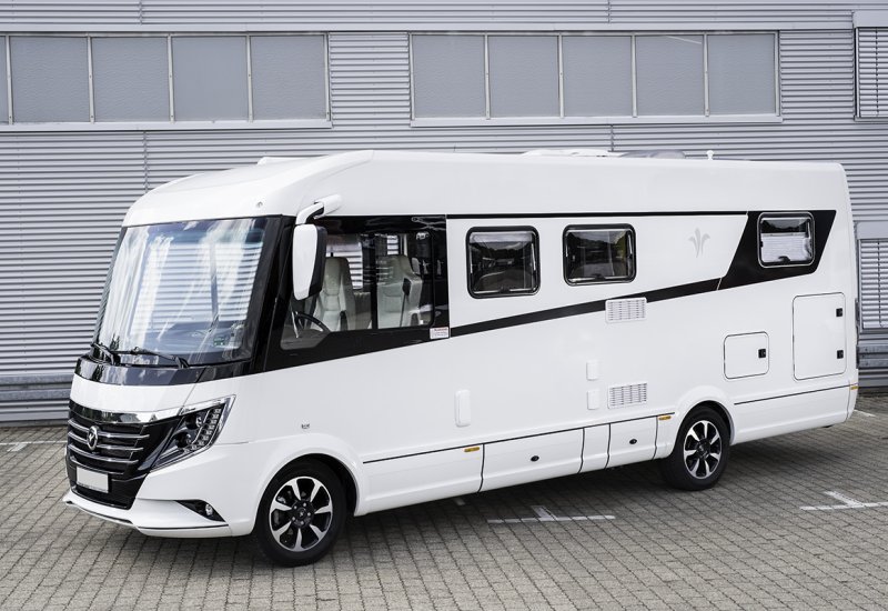 fertig aufbereitetes und poliertes Wohnmobil vor einer Lagerhalle