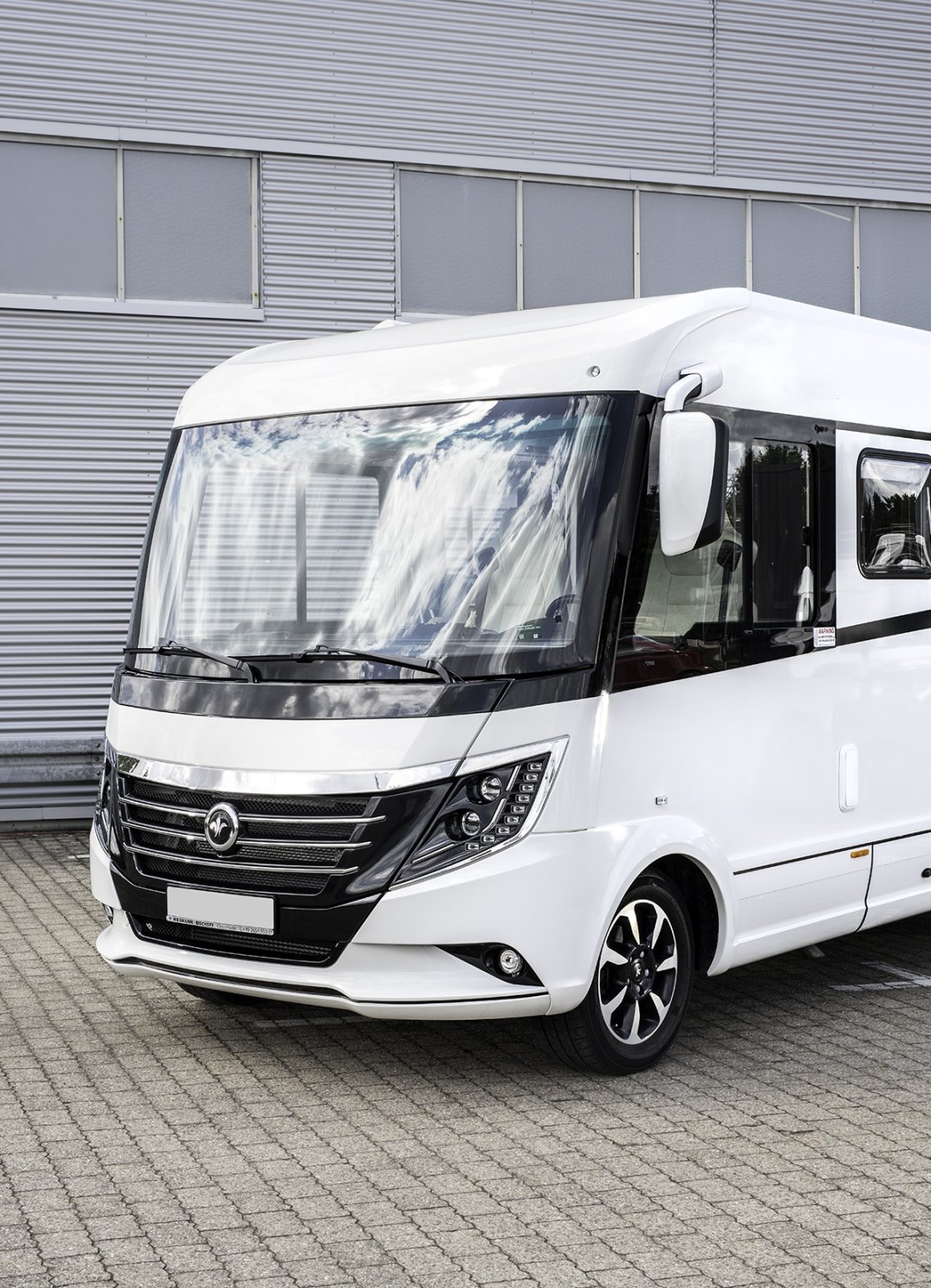 Perfekt gepflegter, glänzender Caravan auf einem Parkplatz.