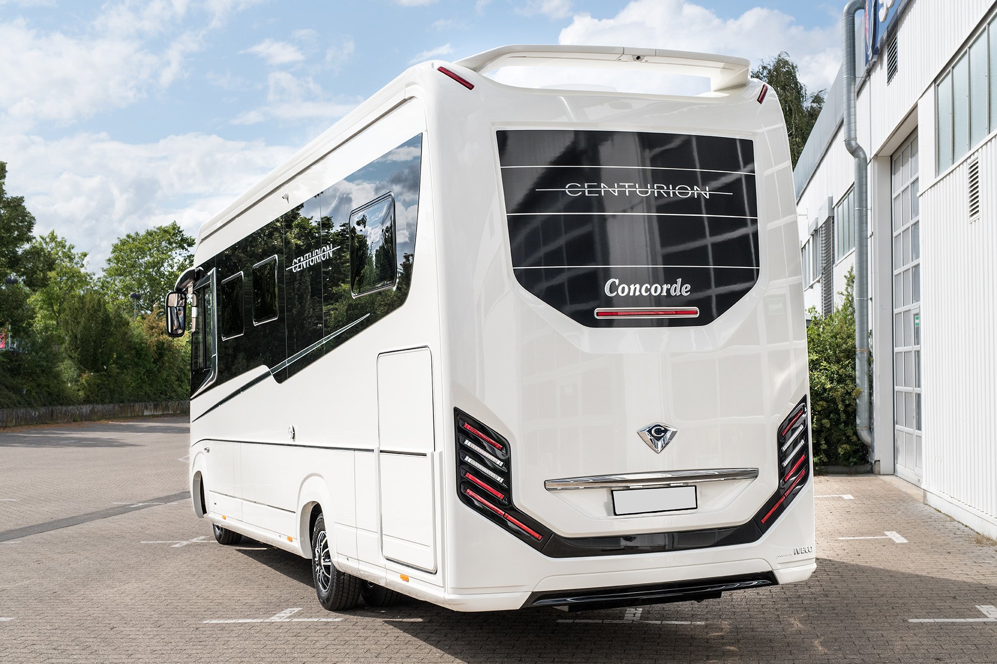 Perfekt gepflegter, glänzender Caravan auf einem Parkplatz.